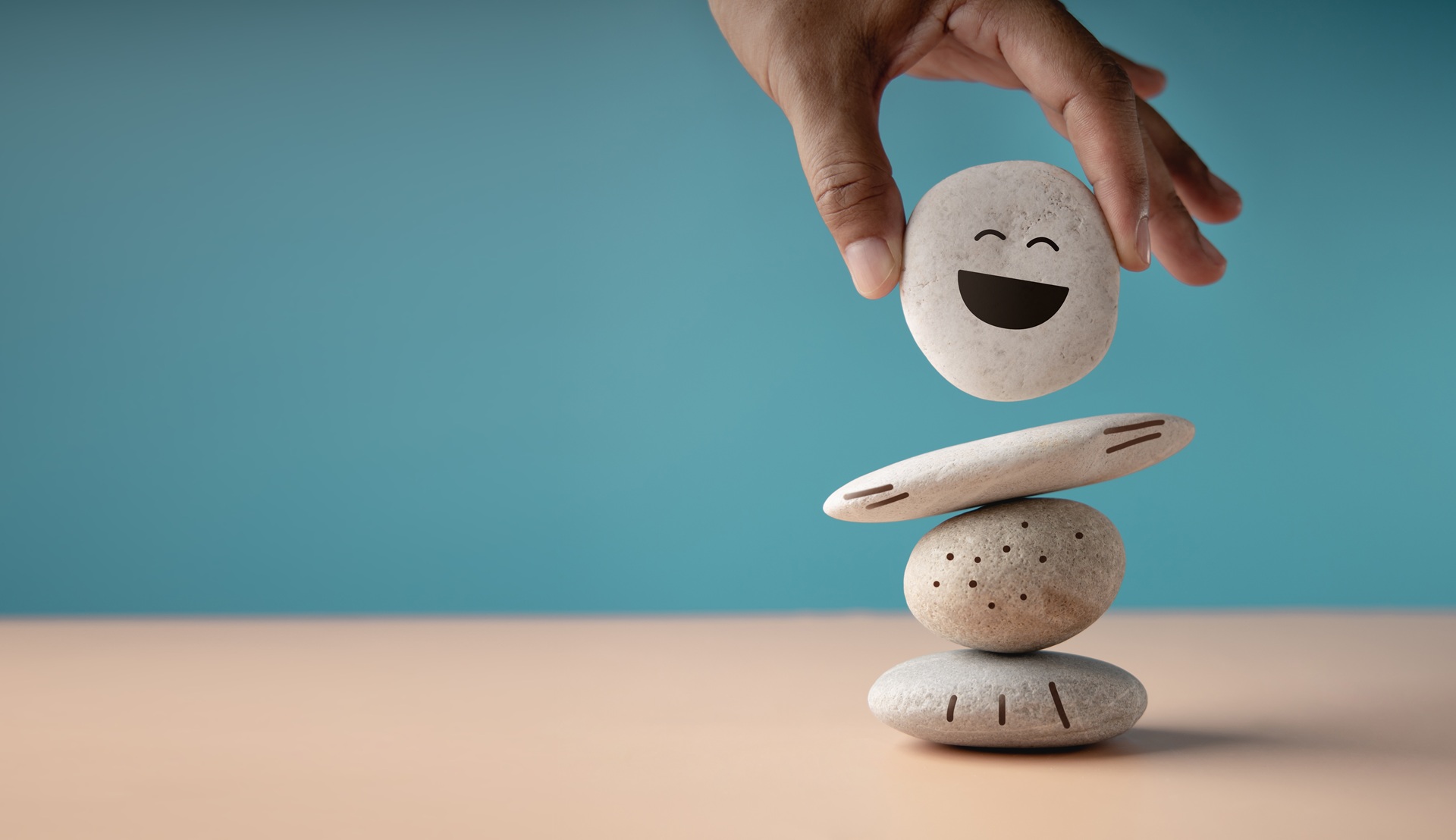 Hand stapelt Steine mit Smiley | Chiropraktik in Berlin